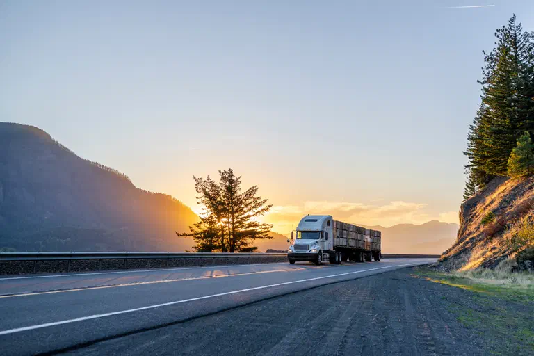 A photo of a semi truck driving down the highway. A photo of a semi truck driving down the highway.